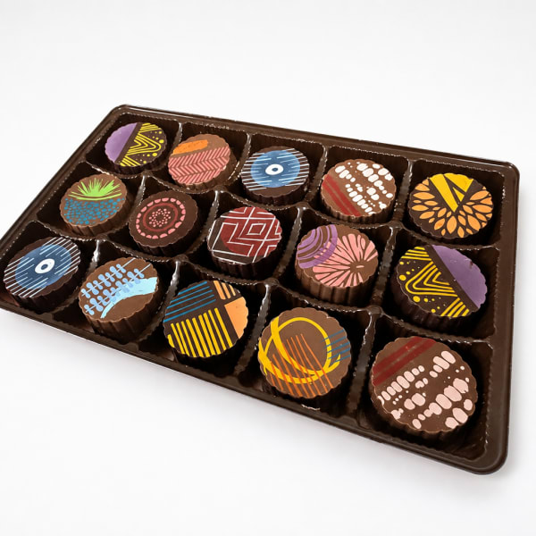 Tray of assorted decorated chocolates in a plastic box