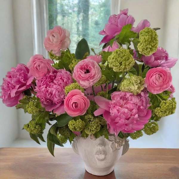 Pink flowers arranged in a sculpted face vase
