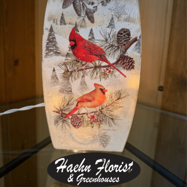 Decorative winter lantern with red cardinals and pinecones