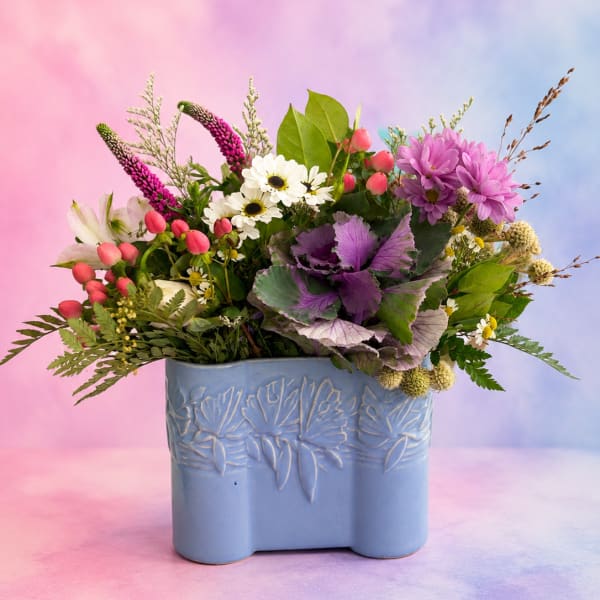 Mixed bouquet in a blue ceramic vase with pink, purple, and white flowers