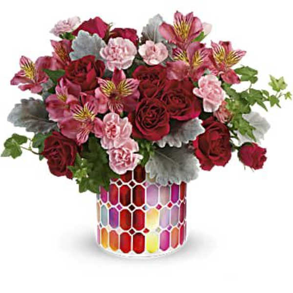 Red roses and pink alstroemeria in a colorful mosaic vase