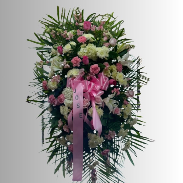 Standing floral spray with pink and white flowers and a pink ribbon