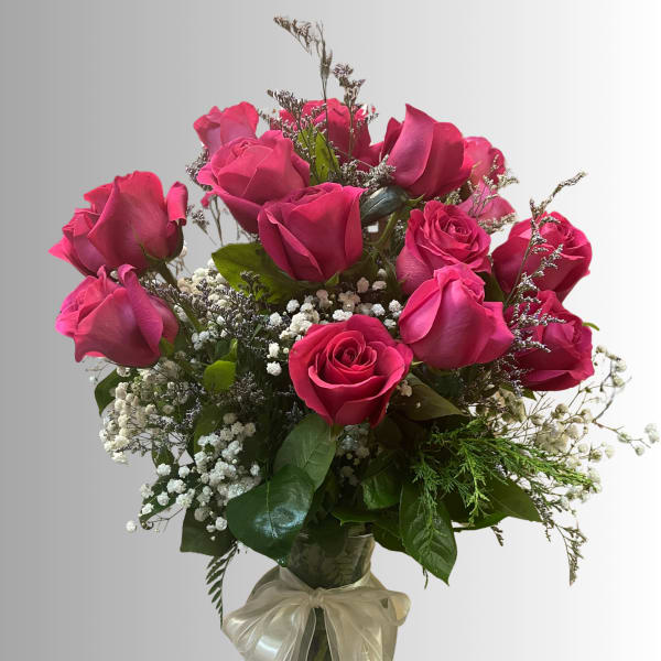 Bouquet of pink roses in a glass vase with a ribbon bow