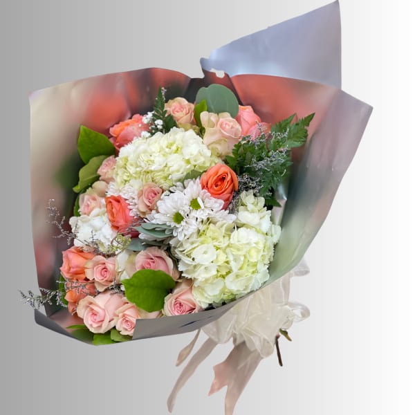 Bouquet of pink roses, white hydrangeas, and white daisies wrapped in pastel paper