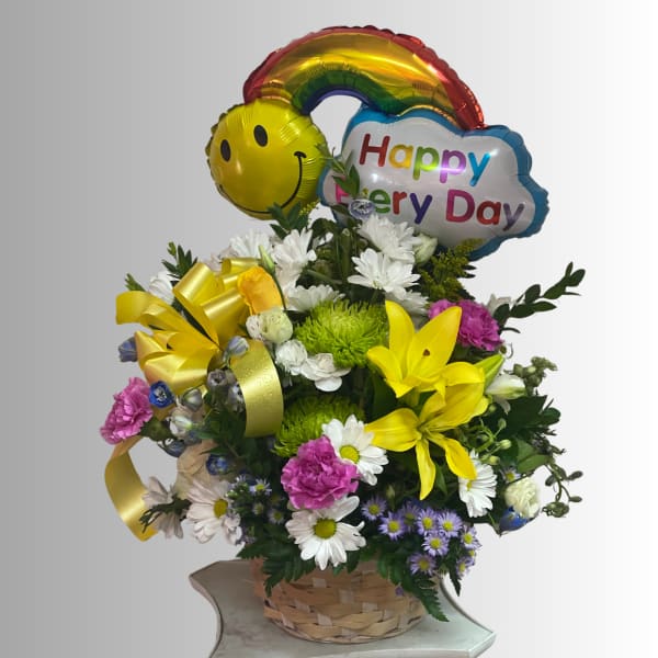 Basket arrangement of mixed flowers with rainbow and smiley balloons
