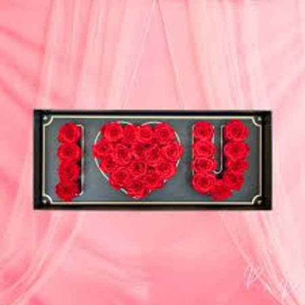 Red roses arranged in an "I ♥ U" display on a pink background
