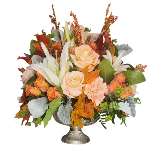 Autumn floral arrangement with peach roses and white lilies in a silver vase