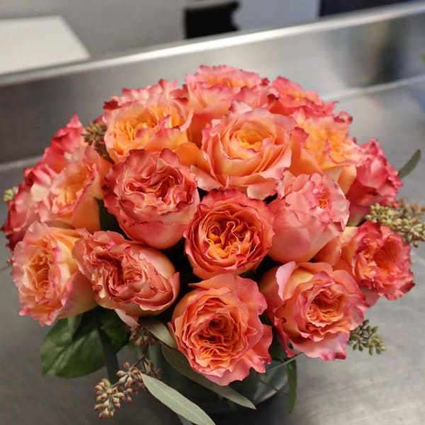 Bouquet of peach and pink roses in a dark vase