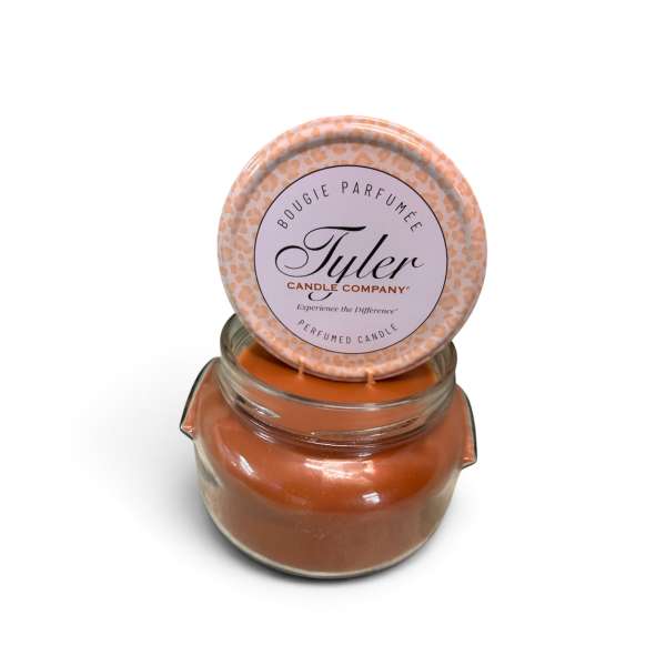 Orange scented candle in a glass jar with a round lid