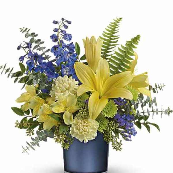 Yellow lilies and blue flowers arranged in a dark vase
