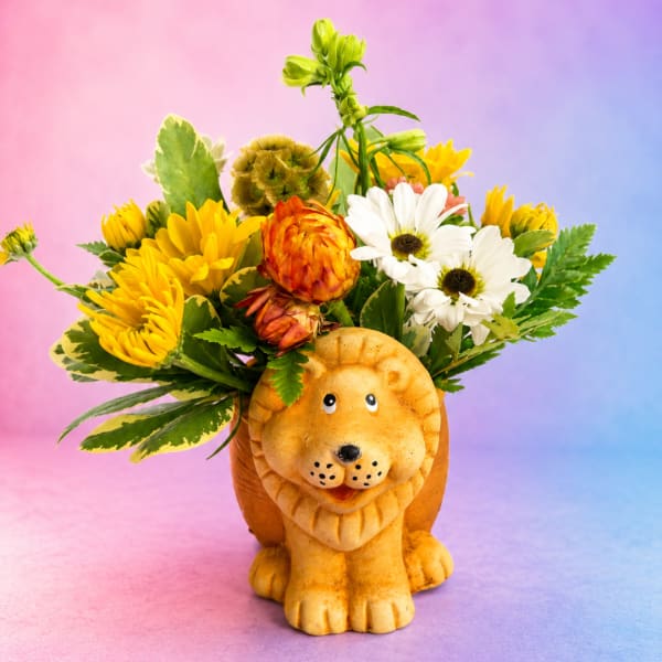Flower arrangement in a lion-shaped container with yellow, white, and orange blooms