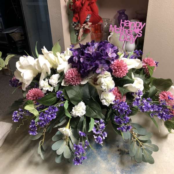 Large purple, white, and pink floral arrangement with a Happy Mother's Day sign