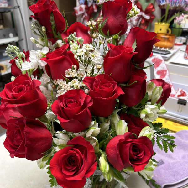 Bouquet of red roses with white filler flowers in a glass vase