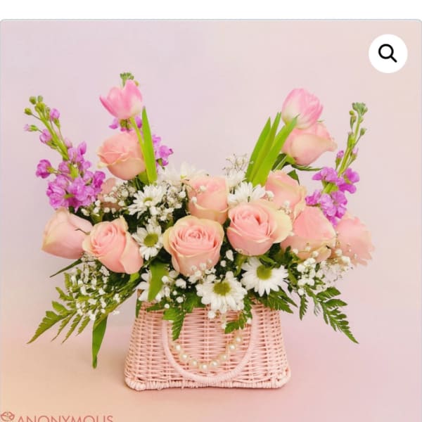 Pink roses and white daisies in a pink woven basket