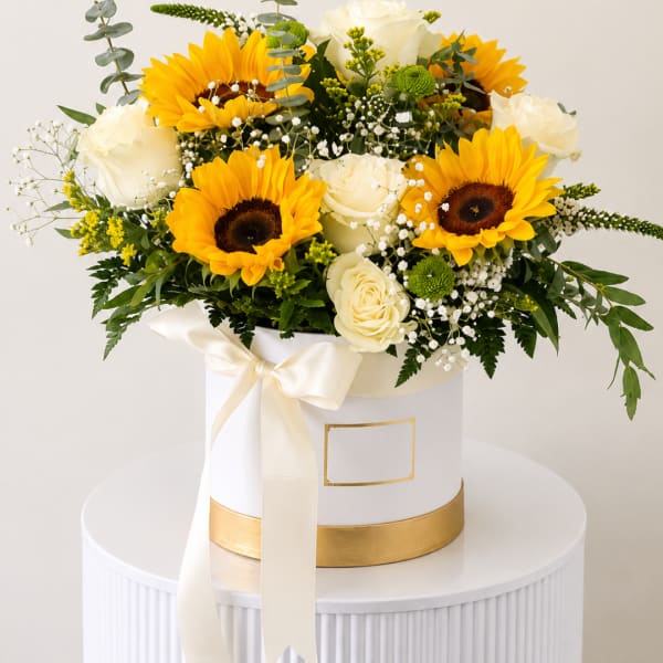 Sunflower and white rose arrangement in a white hatbox with a ribbon