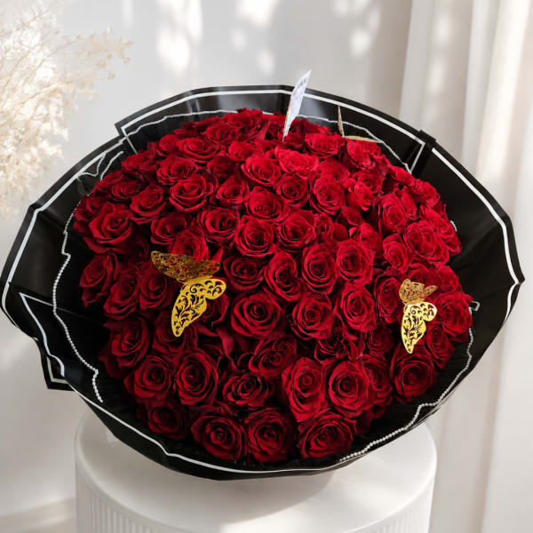 Large bouquet of red roses wrapped in black paper