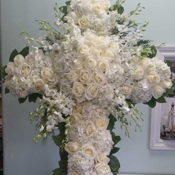 White floral cross arrangement with roses and hydrangeas