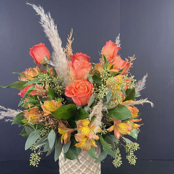 Orange rose and alstroemeria arrangement in a textured vase