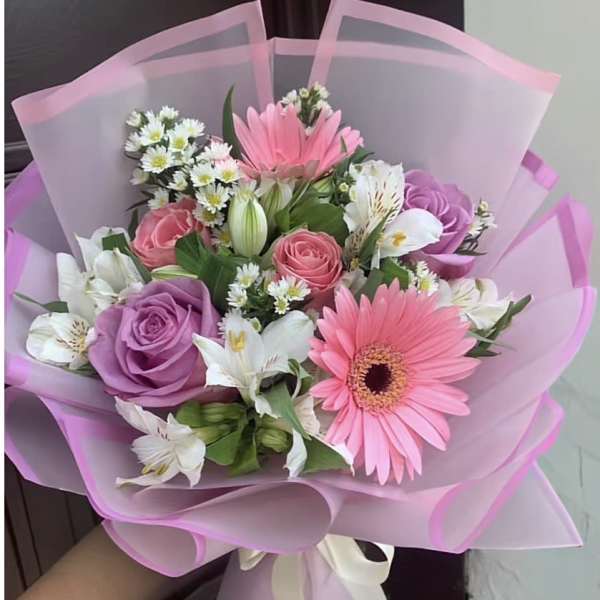 Pink and purple bouquet with gerbera daisies, roses, and white flowers