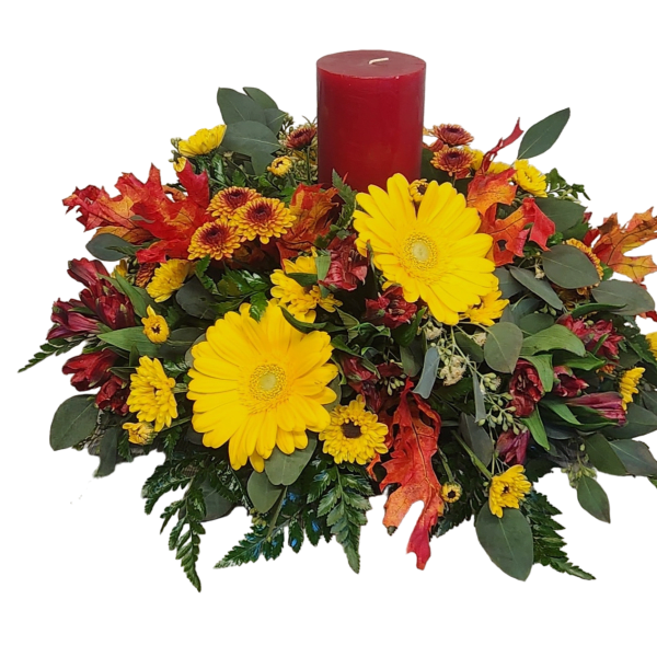 Autumn floral centerpiece with yellow daisies and a red pillar candle