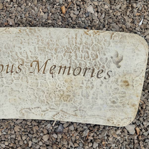 Stone memorial plaque engraved with "Precious Memories"