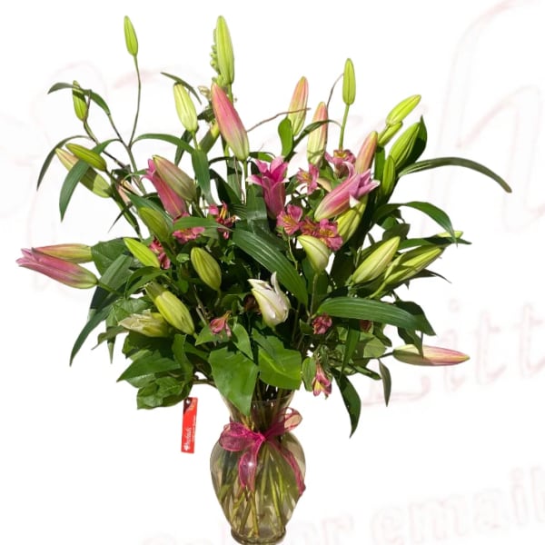 Bouquet of pink lilies in a glass vase with a ribbon