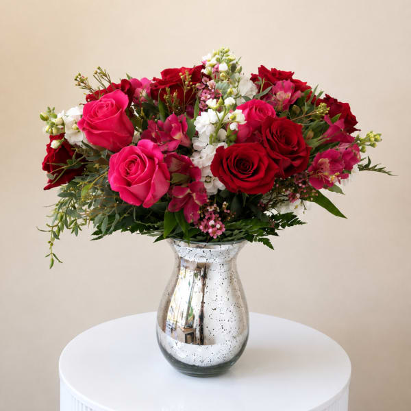 Bouquet of red and pink roses in a silver vase