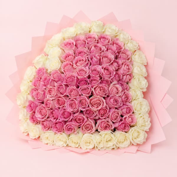 Pink and white rose bouquet wrapped in pale pink paper