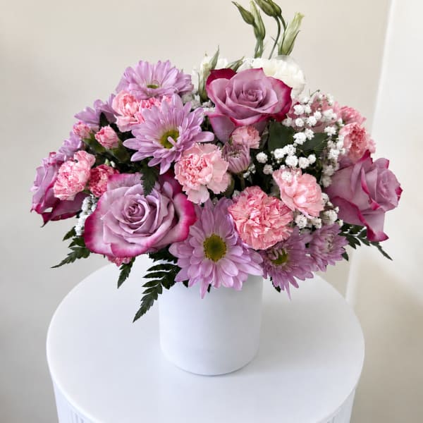 Pink and lavender bouquet in a white vase