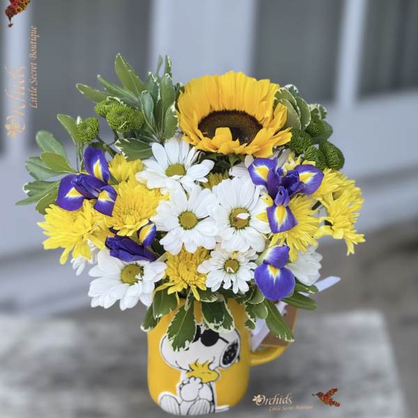 Bouquet of yellow, white, and purple flowers in a Snoopy mug