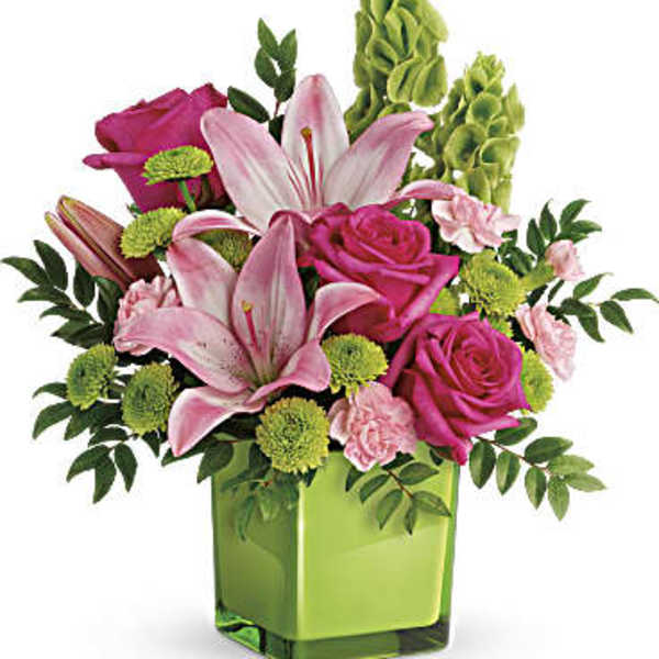 Pink lilies and roses in a green glass vase