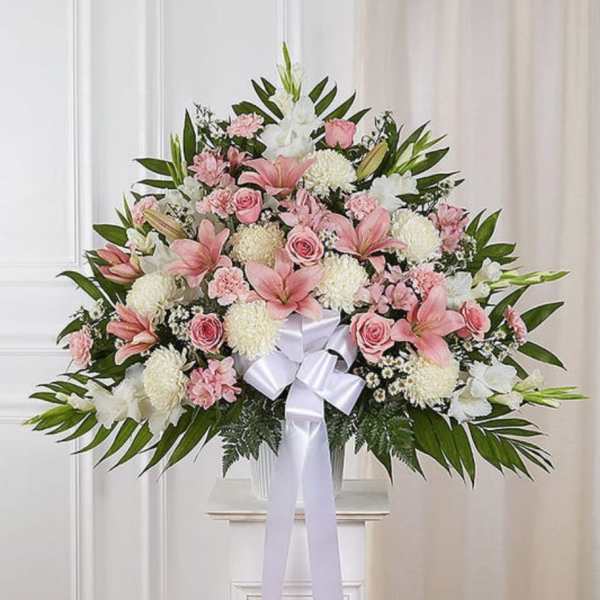 Large pink and white floral spray with a white ribbon bow