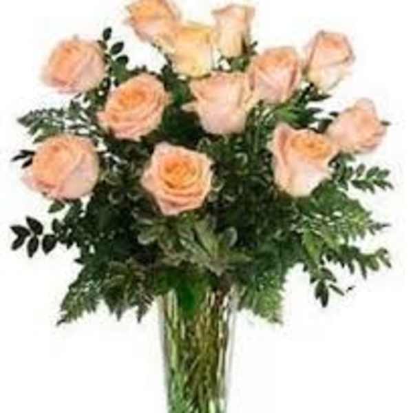 Peach roses arranged in a clear glass vase