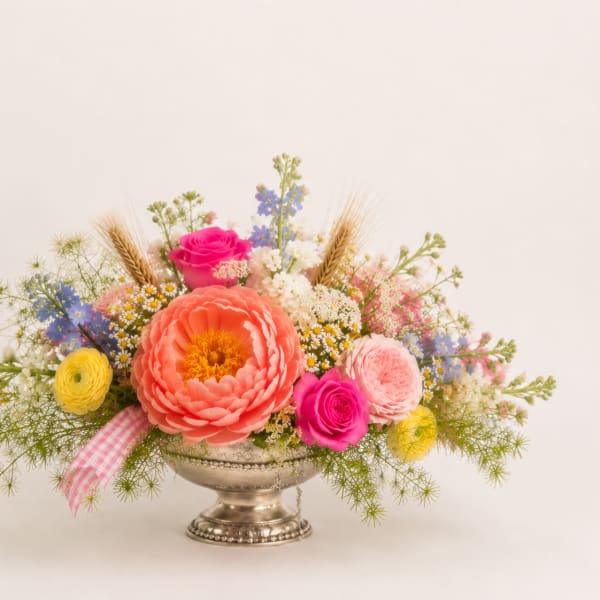 Colorful mixed flower arrangement in a silver pedestal vase