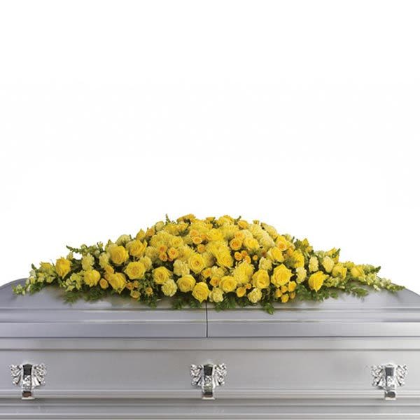 Long yellow rose and carnation casket spray on a silver casket