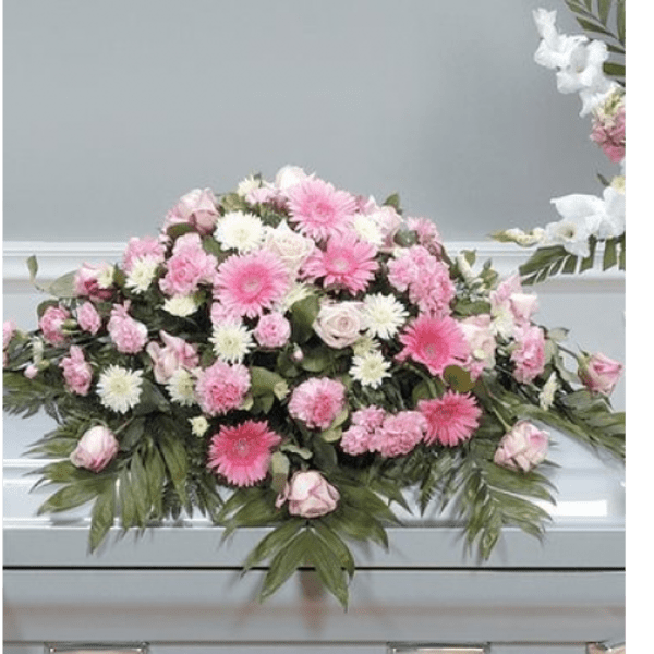 Pink and white floral casket spray with roses and daisy-like blooms