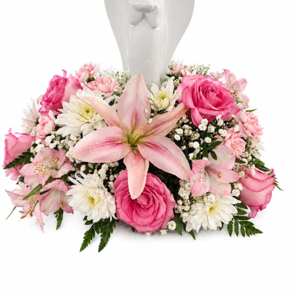 Pink and white floral arrangement with an angel figurine centerpiece