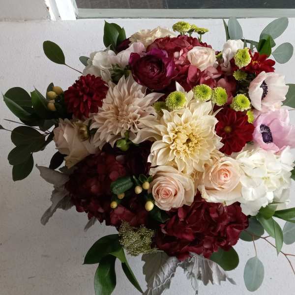 Mixed bouquet of burgundy, blush, and white flowers with eucalyptus