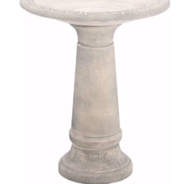 Stone pedestal birdbath with a shallow round basin