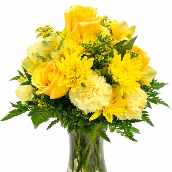 Yellow roses and daisies arranged in a clear glass vase
