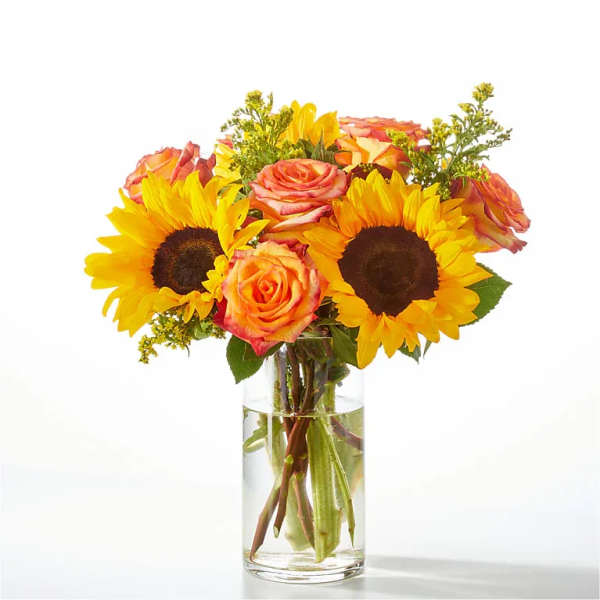 Bouquet of sunflowers and orange roses in a clear glass vase