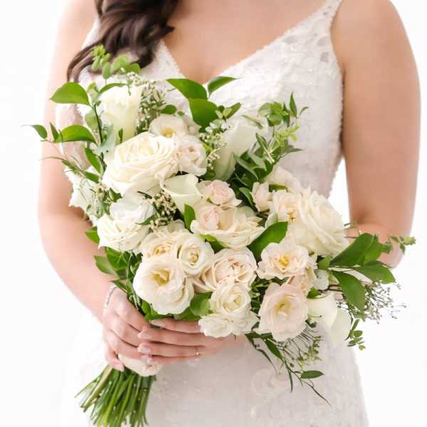 Bride holding a white bouquet of roses and calla lilies