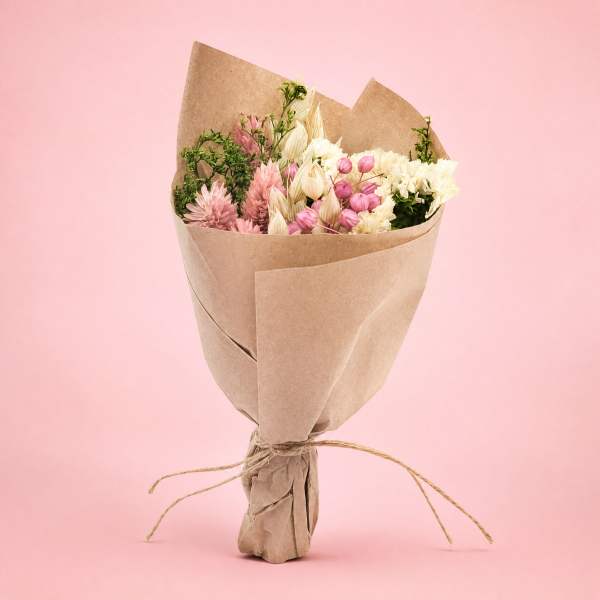 Bouquet of pink and white flowers wrapped in brown paper