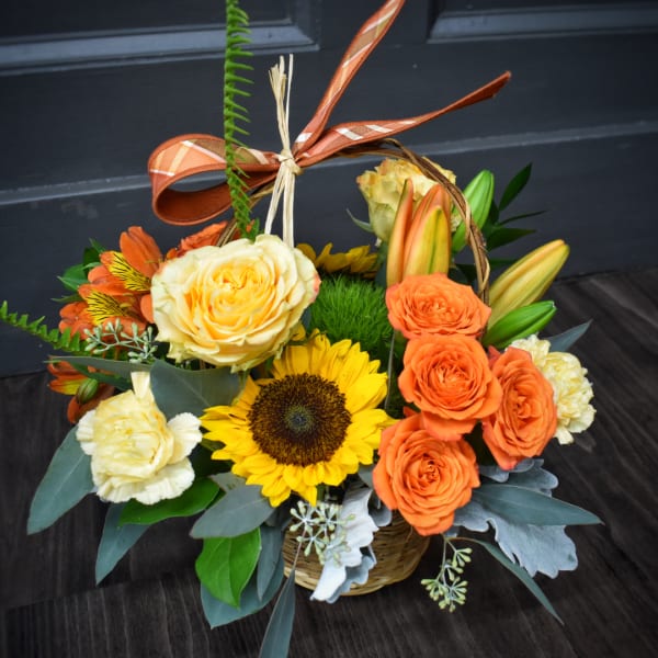 Basket arrangement with roses, sunflowers, lilies, and carnations