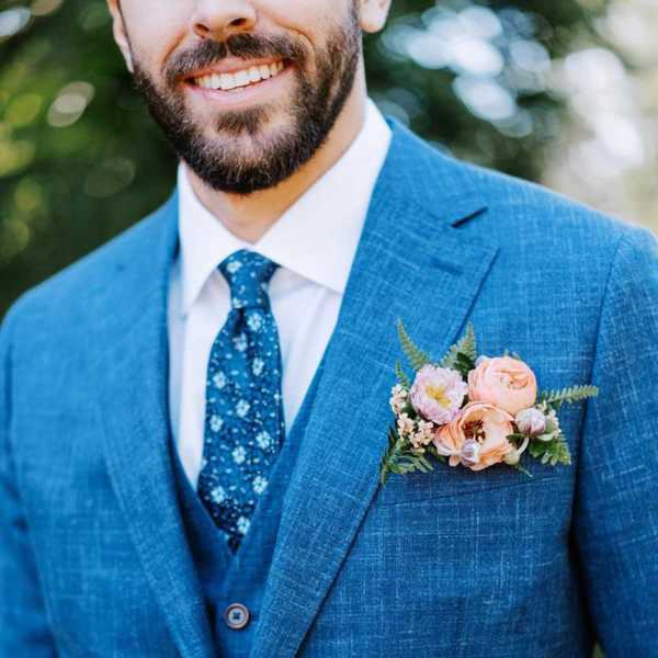 Boutonniere with peach flowers on a blue suit jacket