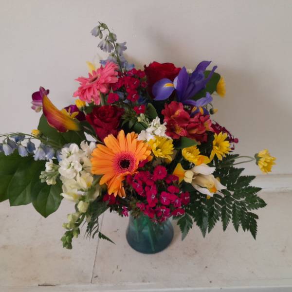 Colorful mixed bouquet in a blue glass vase