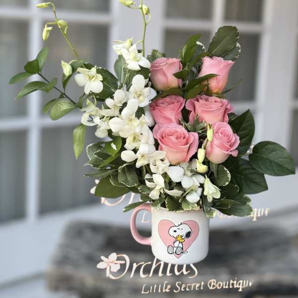 Pink roses and white orchids in a Snoopy mug vase