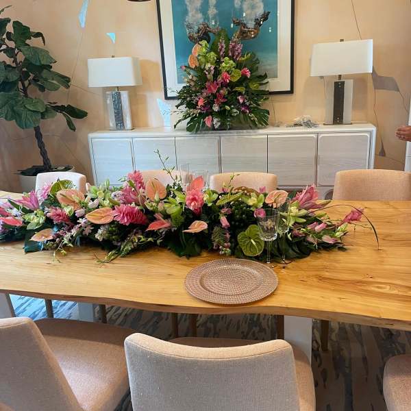 Long pink and white floral table runner with matching tall arrangement on a dining sideboard