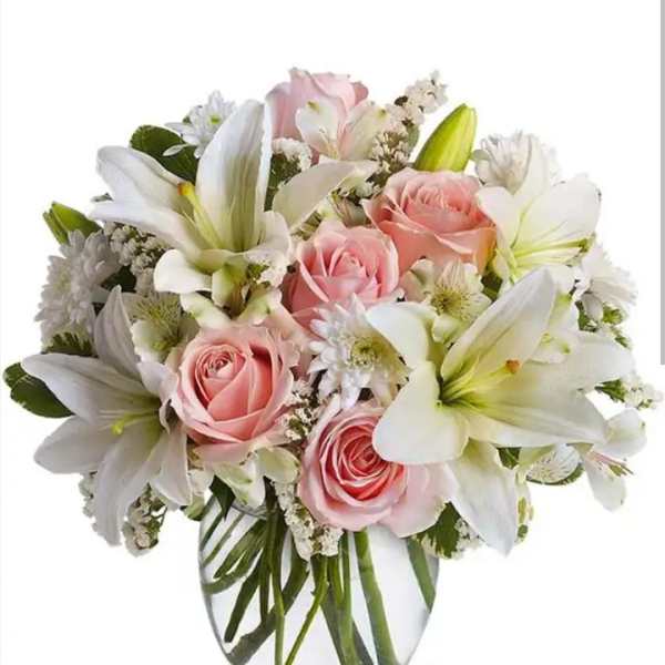 Pink roses and white lilies in a clear glass vase