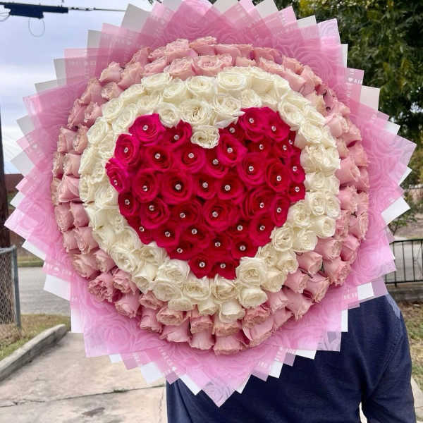Heart-shaped bouquet of pink and white roses with a red rose center